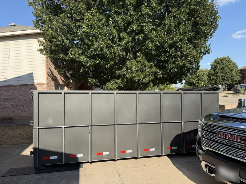 Hot Mess Haulin roll-off dumpster set on protective boards in a customer driveway